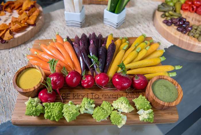 cutting board with lots of colorful vegetables and dip