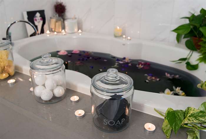 bath tub with candles and flower petals