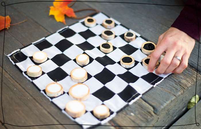 person playing checkers on picnic table