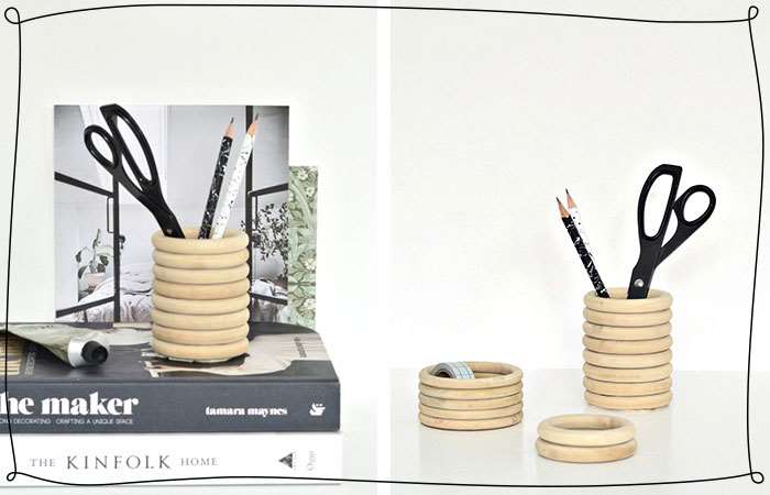 a wooden ringed pencil holder on a desk