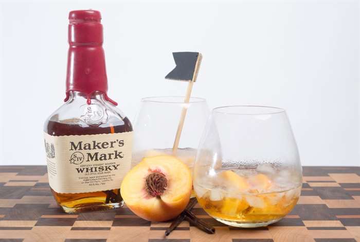 tumbler glasses with peaches and whiskey