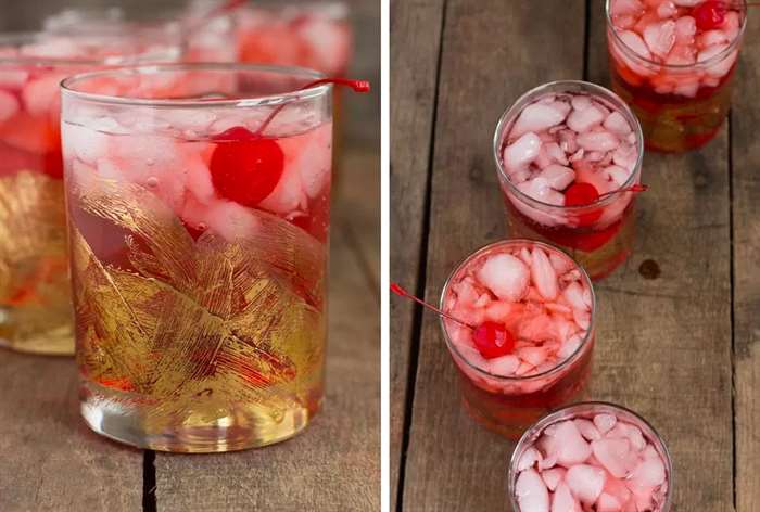 tumbler glasses with cherries and whiskey