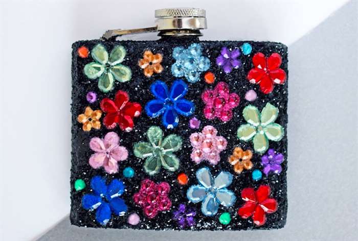 whiskey flask decorated with bedazzled in a flower pattern