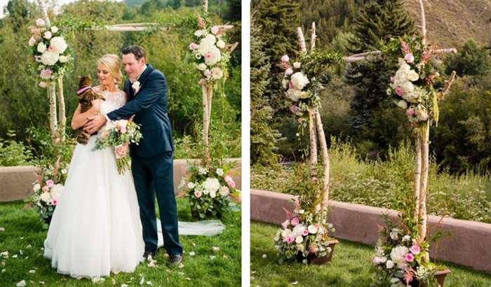 bride and groom with pet cat at flowered arch