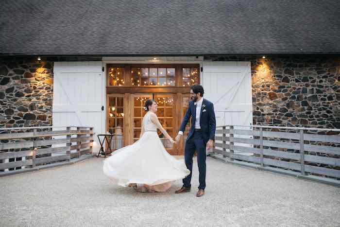 bride and groom dancing in front of barn venue