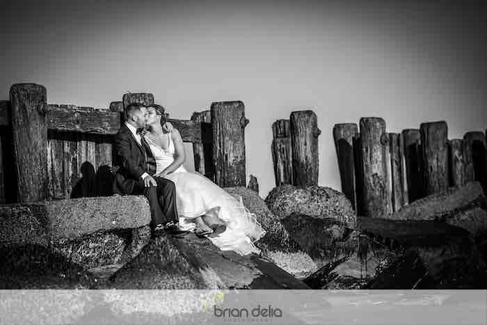 bride and groom kissing on the shore