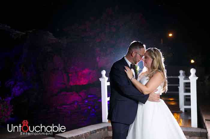 bride and groom kissing under a spotlight