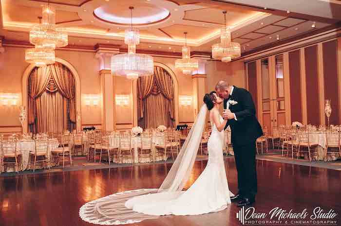 bride and groom kissing in grand ballroom