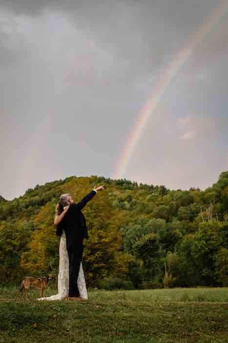 bride and groom under a rainbow