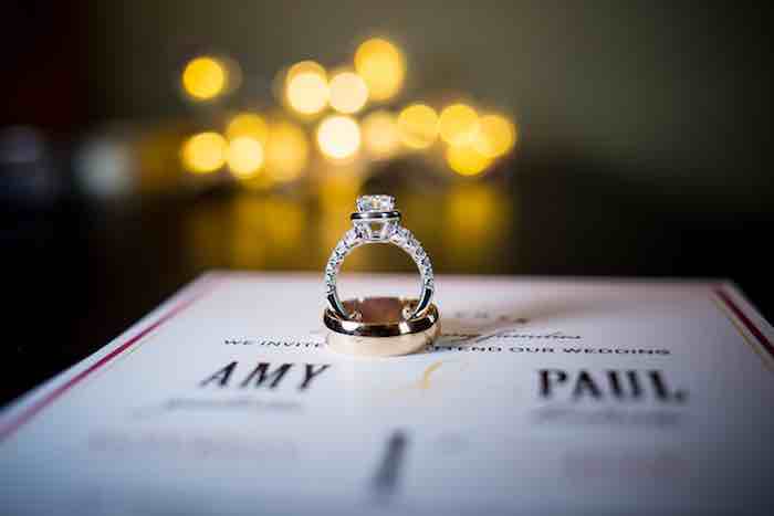 wedding ring sitting on top of wedding program