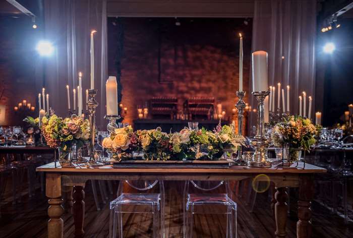 Table with floral arrangements and tall silver candlesticks