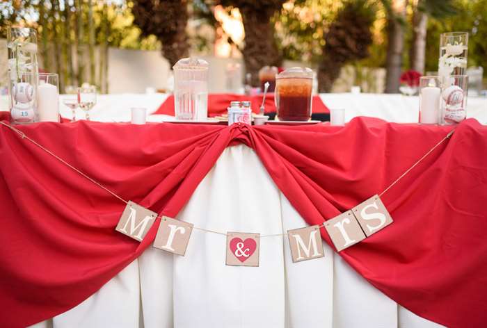 Red and white sweetheart table with 'Mr. and Mrs.' sign