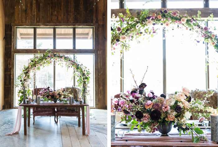 Wood table with mauve colored chairs and elegant floral arc