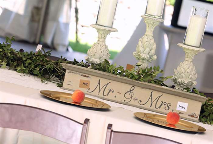 Simple white table with greenery and peaches 