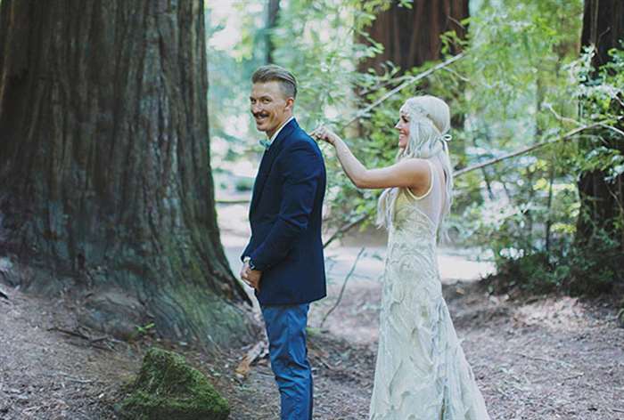 Groom looking at camera while bride taps him on the shoulder