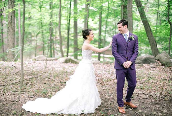 Bride and groom in purple tuxedo in the woods