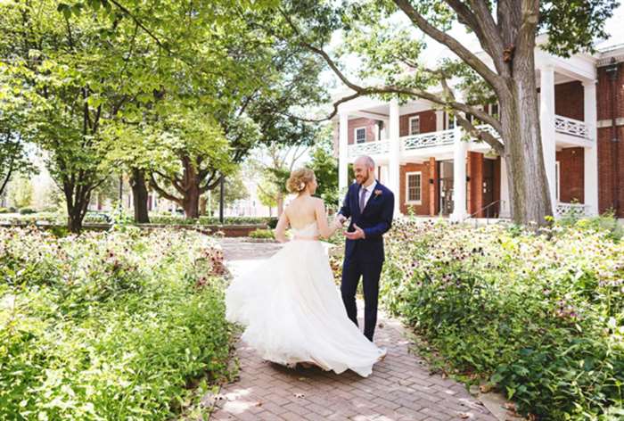 Bride spinning in dress with groom in a garden