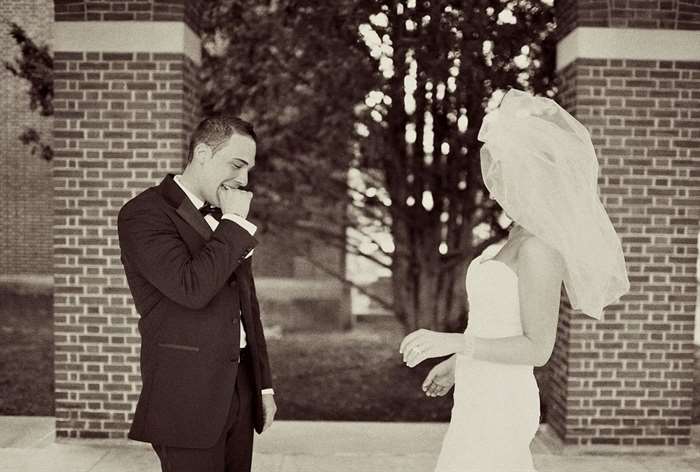 Groom looking at bride under brick arches