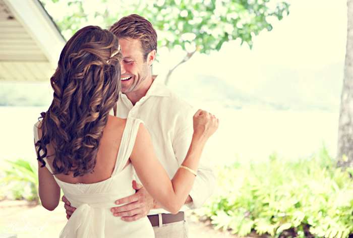 Groom smiling and holding his bride's waist