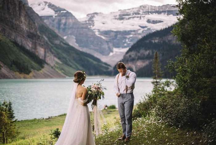 Mountain river background with emotional groom and bride