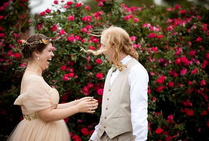 Couple gasping at eachother with bright pink flowers in background