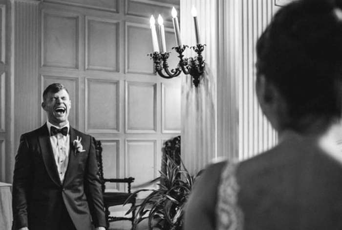 Groom smiling big while looking at his bride