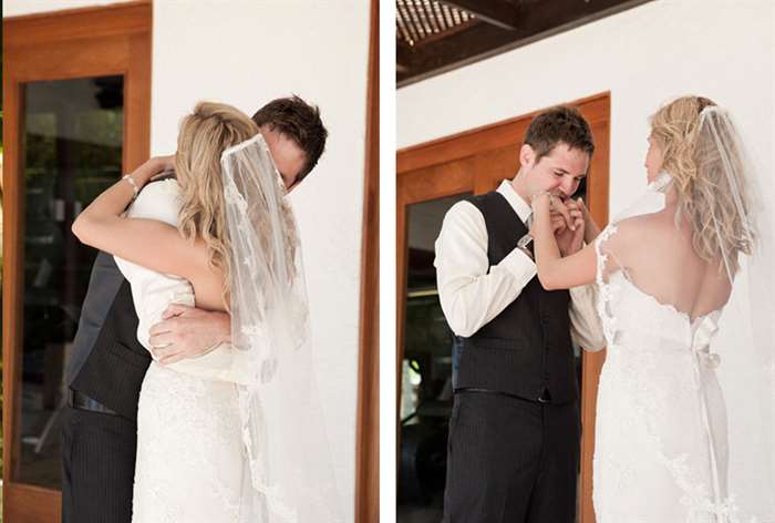 Bride and groom hugging with groom kissing bride's hands