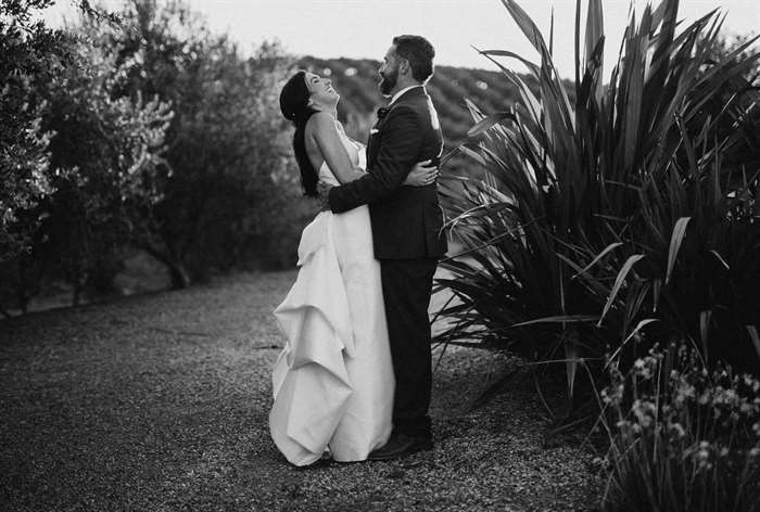 Couple hugging each other and smiling among tropical plants