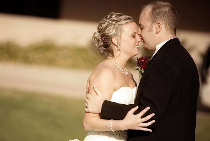 Bride and groom embracing with eyes closed