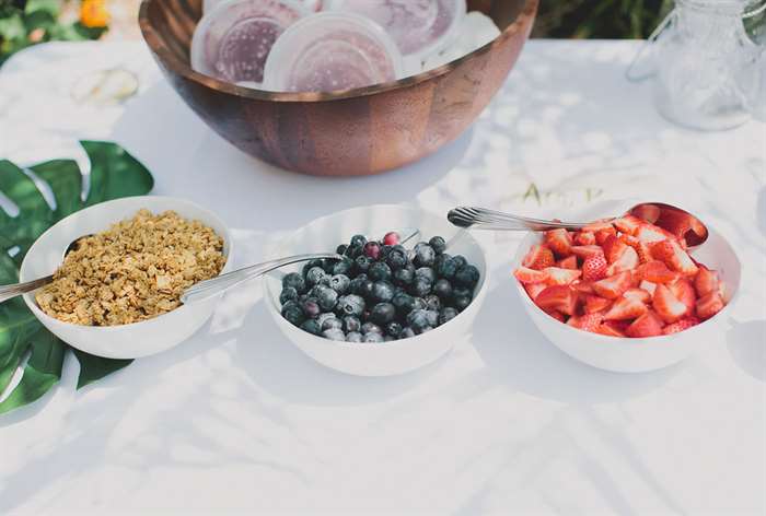 Self-serve acai bowl spread with palm leaves