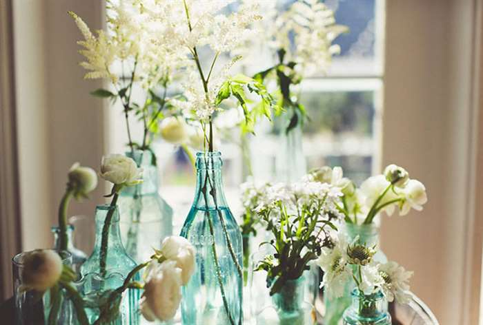 White flowers in clear blue bottles