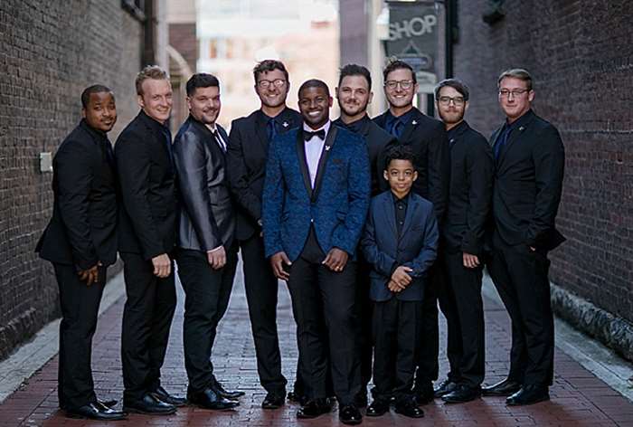 wedding party stands in brick alley