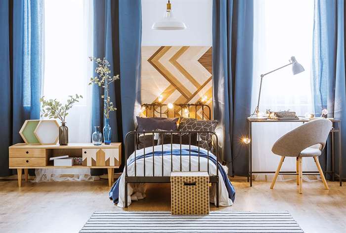 Wooden headboard and blue curtains. 