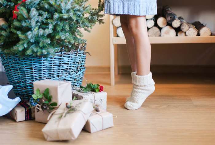 Feet on tip toes next to tree in basket.