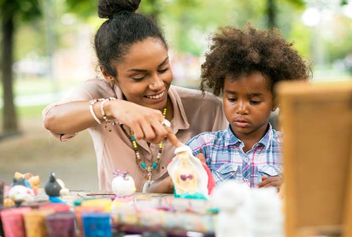 Woman and little girl painting outside.