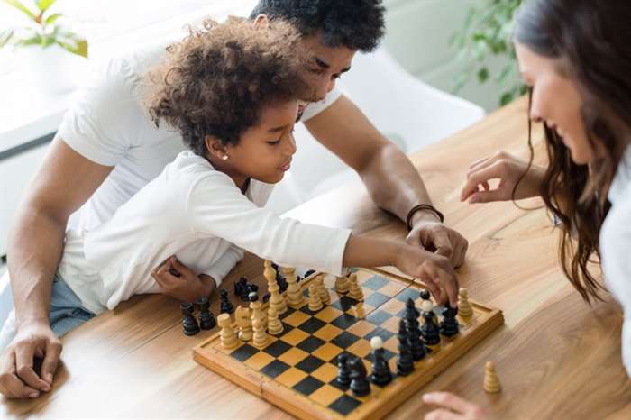 Gia đình hạnh phúc chơi cờ cùng nhau tại nhà của họ