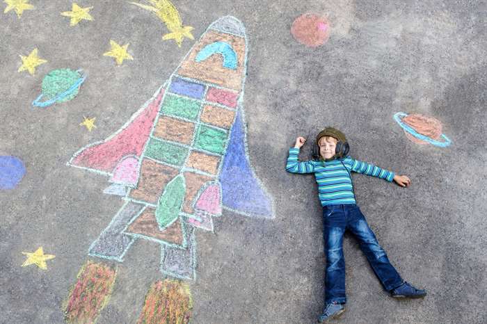 little kid boy flying by a space shuttle chalks picture