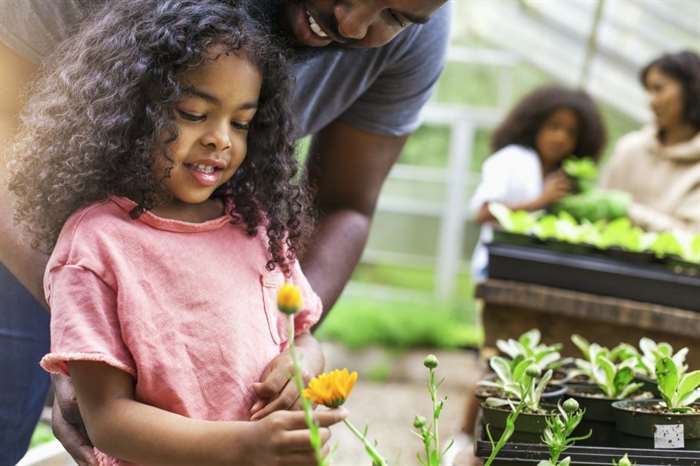 girl and dad gardening flowers