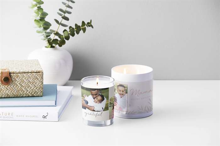 glass and ceramic candle with family photos on a white table with table decorations