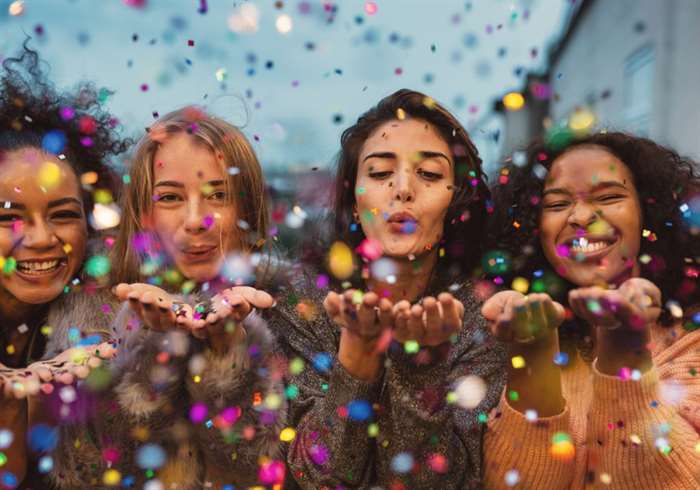 16 year olds blowing confetti from hands. 