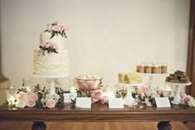 Bánh cưới và đồ ngọt được bao quanh bởi hoa.